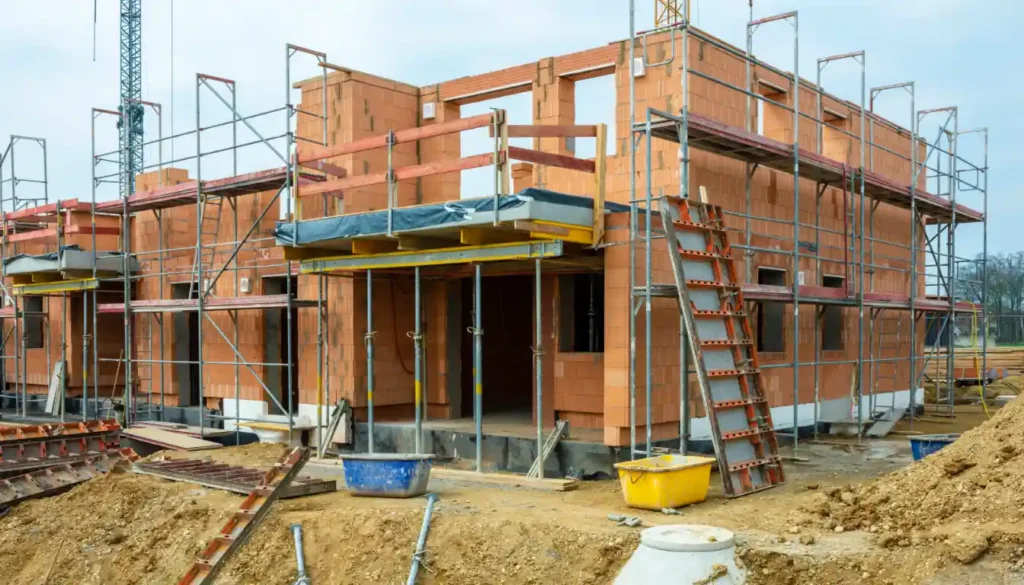 Rohbau eines Hauses mit sichtbarer Ziegelbauweise, Baustelle im frühen Baufortschritt.